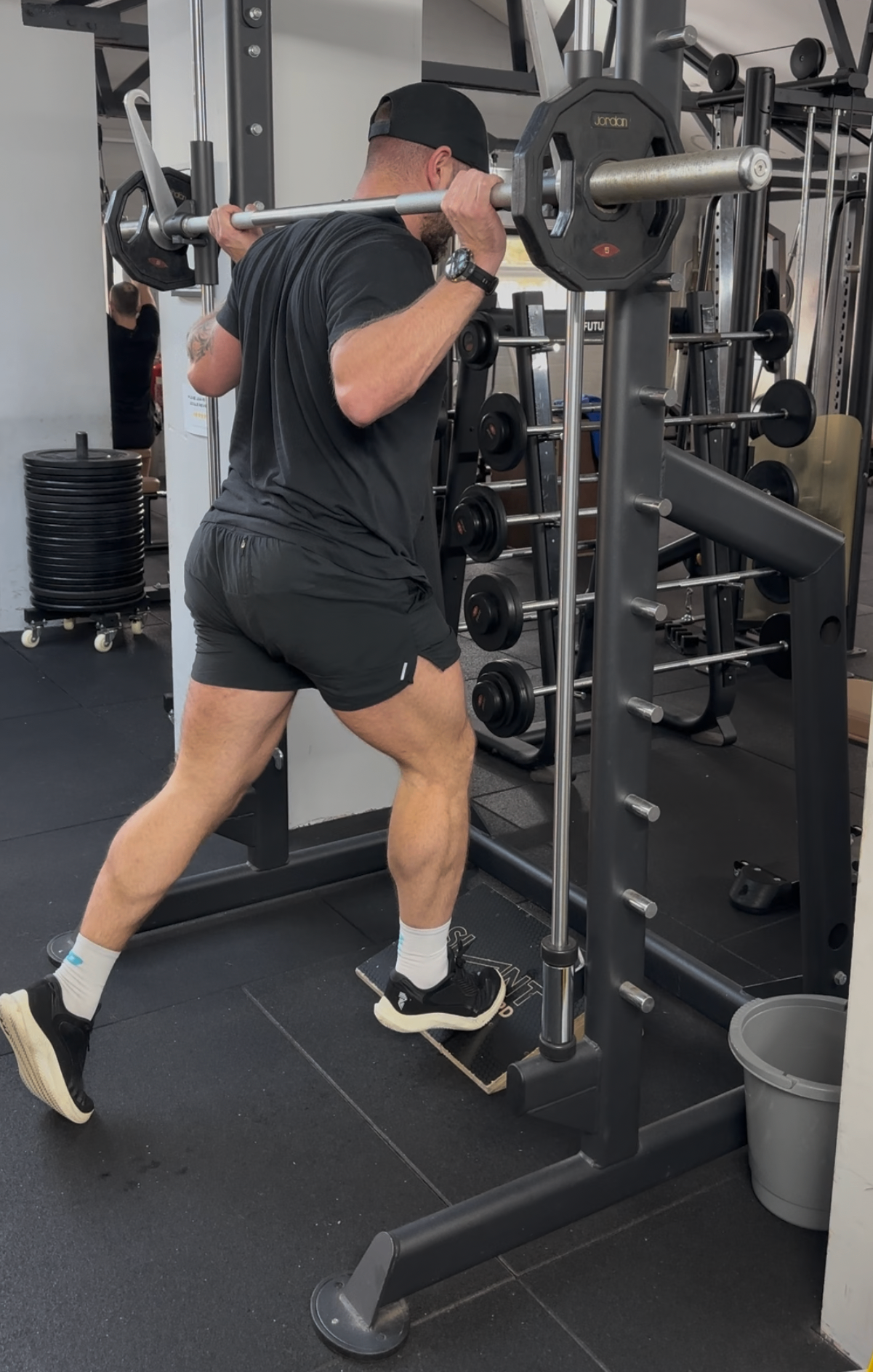 Tom Shaw coaching a split-squat under load in the gym